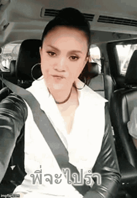 a woman is taking a selfie in the back seat of a car in a language other than english .