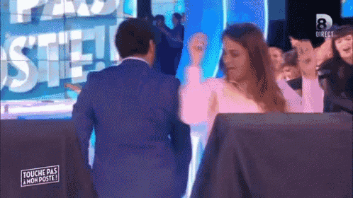 a man in a suit and a woman in a pink shirt are on a television show called touche pas