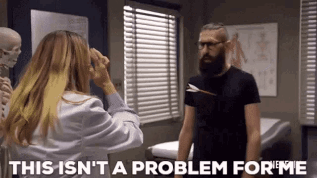 a man with a beard is standing next to a woman in a lab coat and a skeleton .