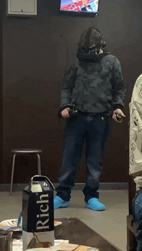 a man wearing a virtual reality headset stands in front of a box of rich milk