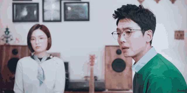 a man in a green sweater is looking at a woman