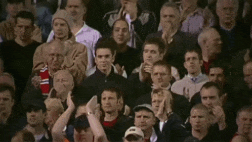 a crowd of people in a stadium with a man wearing a hat that says nike