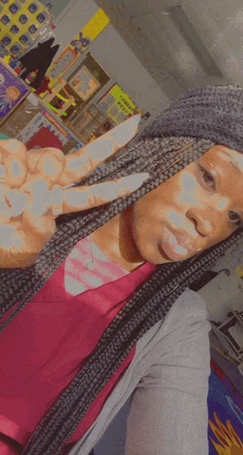 a woman wearing a hat that says ucsd makes a peace sign