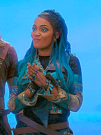 a woman with blue hair is wearing a leather jacket