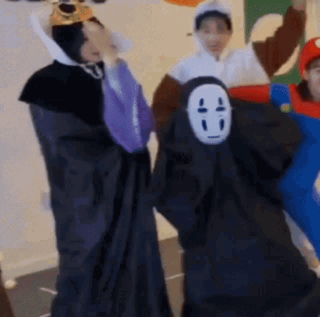 a group of people are dressed in costumes and one of them has a mask on his face .