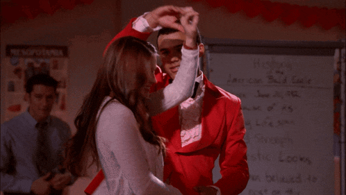 a man and a woman are dancing in front of a white board that says history