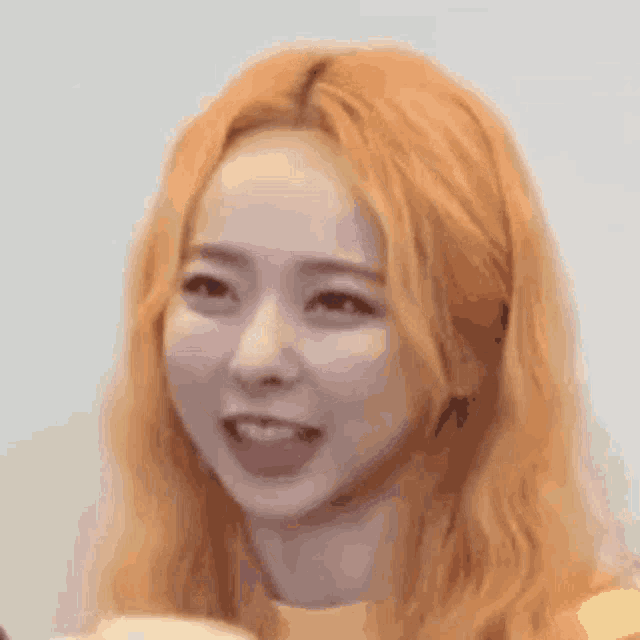 a close up of a woman 's face with long orange hair .