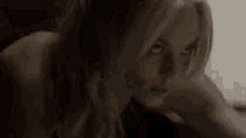 a close up of a woman in a dark room looking at the camera .