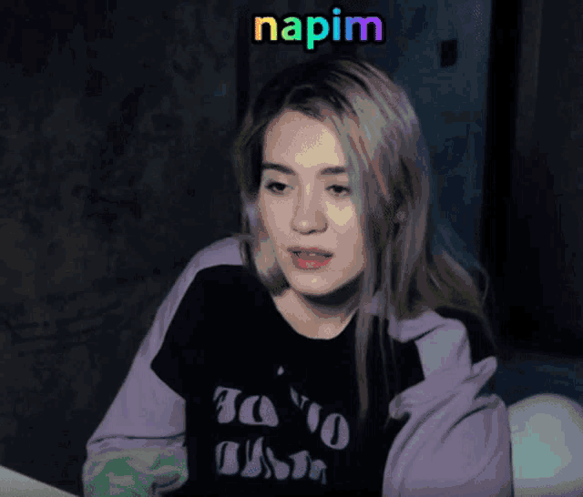 a woman wearing a purple jacket and a t-shirt that says to no one