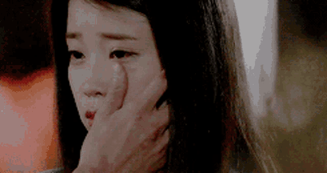 a close up of a person touching a woman 's face with their hand .
