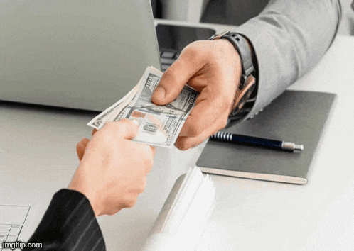 a person is handing another person a stack of money .