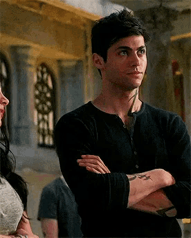 a man with his arms crossed is standing next to a woman .