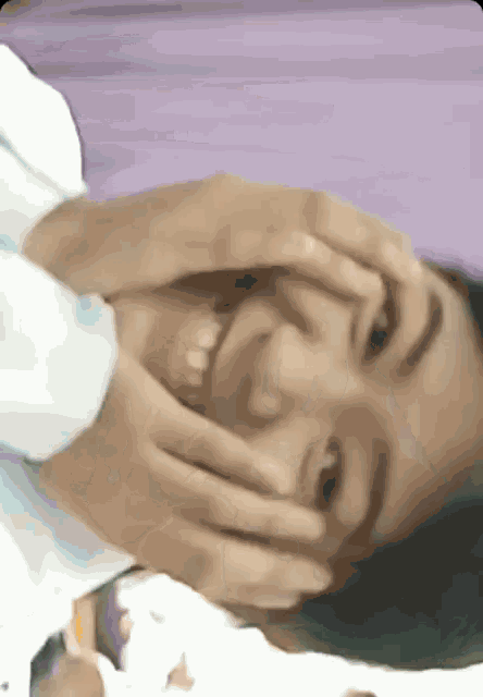a close up of a woman covering her face with her hands and smiling .