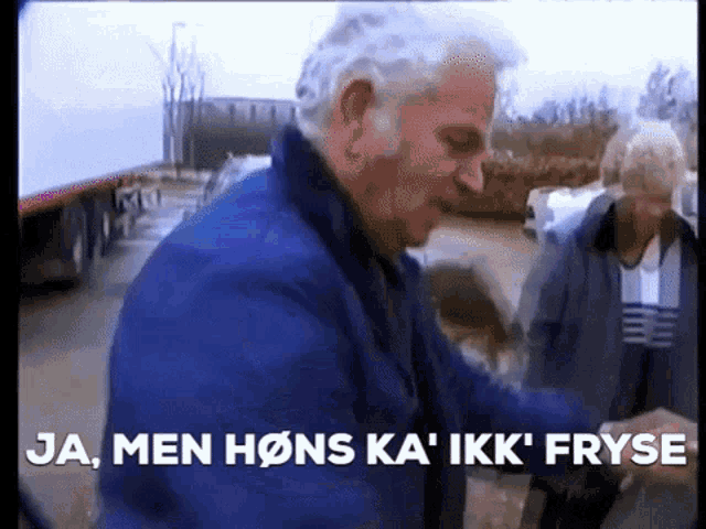 a man in a blue jacket with the words ja men hons ka ' ikk fryse behind him