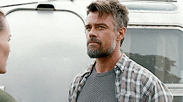 a man in a plaid shirt stands next to a woman in a green shirt