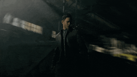 a man in a black jacket is walking through a dark building