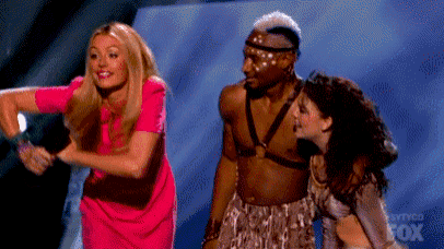 a woman in a pink dress is standing next to a man in a native american costume .