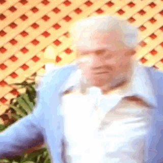 a blurry picture of an older man in a blue jacket and white shirt