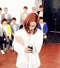 a man with red hair is standing in front of a group of men