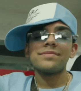 a young man wearing a hat and sunglasses smiles for the camera