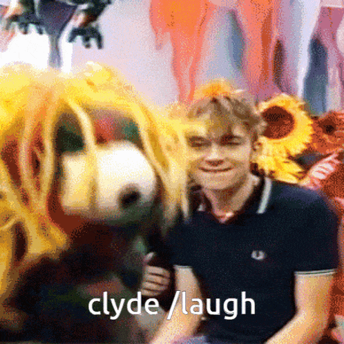 a man sitting next to a stuffed animal with the words clyde laugh on the bottom