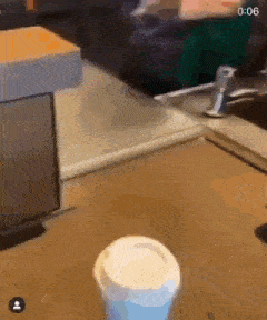 a cup of coffee is sitting on a counter next to a faucet .