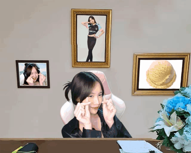 a woman sitting at a desk with a picture of an ice cream scoop on the wall