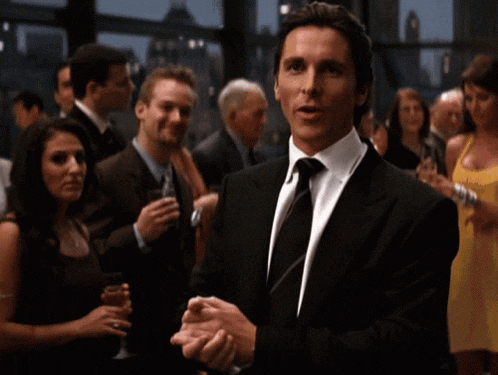 a man in a suit and tie stands in a crowd