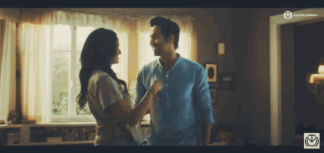 a man and a woman are looking at each other in a room with the word company on the bottom right