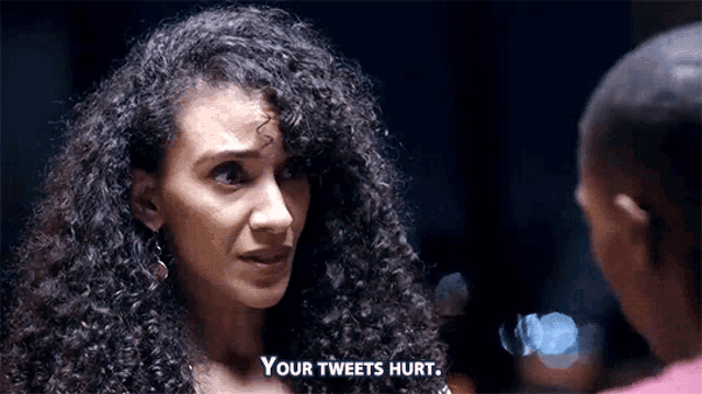 a woman with curly hair is talking to a man and says " your tweets hurt " .
