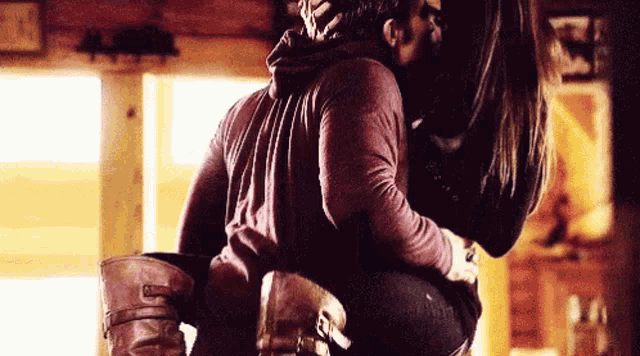 a man is carrying a woman in his arms and they are kissing