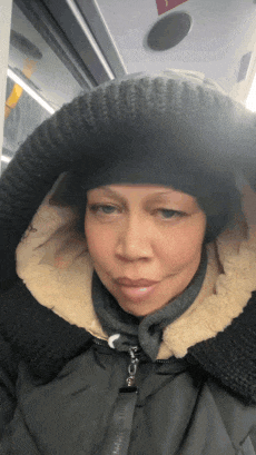 a woman wearing a hat and a jacket with a hood