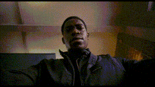 a man in a black jacket is looking up at the camera