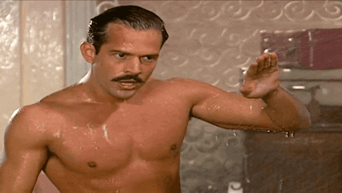 a shirtless man with a mustache is in a shower