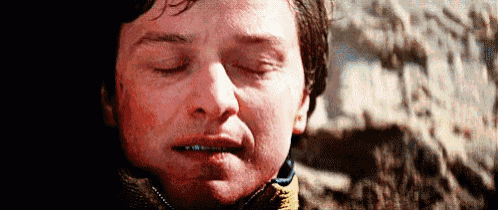 a close up of a man 's face with his eyes closed and a red face .