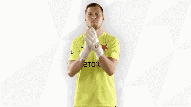 a man wearing a yellow shirt with etoro on it