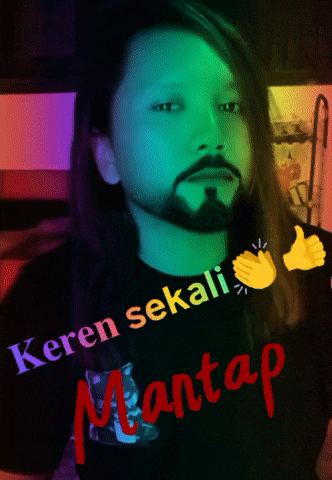 a man with long hair and a beard wears a shirt that says keren sekali mantap