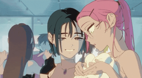 a girl with pink hair is touching another girl 's cheek