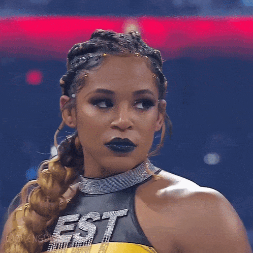 a female wrestler wearing a black and yellow outfit with the word est on it
