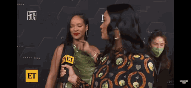two women are standing next to each other with a microphone that says et on it