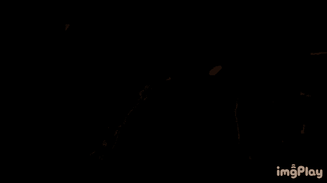a man in a mask is standing in the dark looking at something .