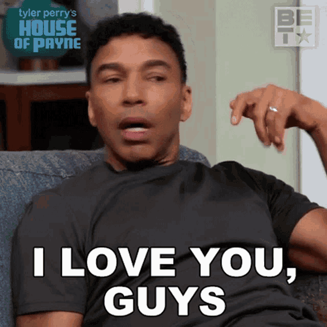 a man is sitting on a couch and says i love you guys