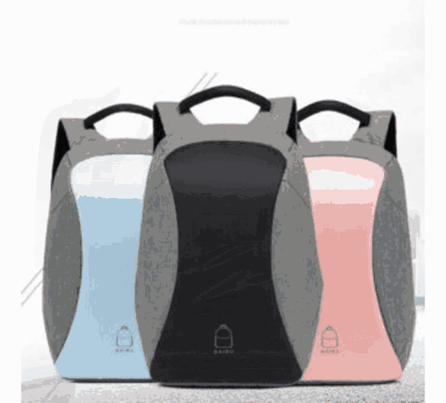 three different colored backpacks are lined up on a table