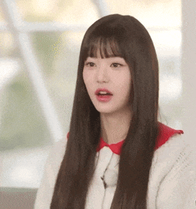 a woman with long hair and a red collar is wearing a white sweater and a red collar .