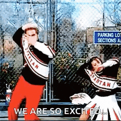 two spartan cheerleaders are dancing in front of a parking lot