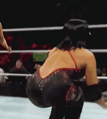 a woman in a red and black dress is standing in a ring .