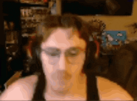 a blurry picture of a man wearing headphones and a tank top