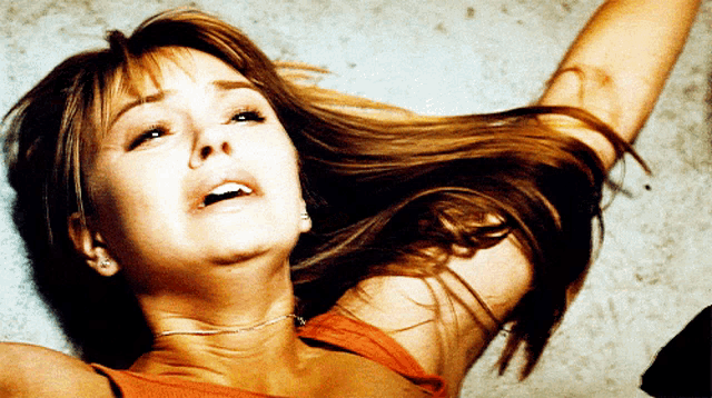 a woman with long hair is laying on the floor with her eyes closed