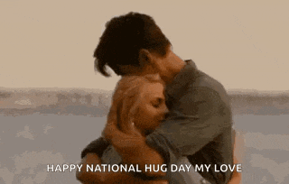a man and a woman are hugging each other on a beach .