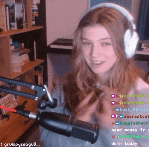 a girl wearing headphones stands in front of a microphone with the words grumpyseagull_ on the bottom right